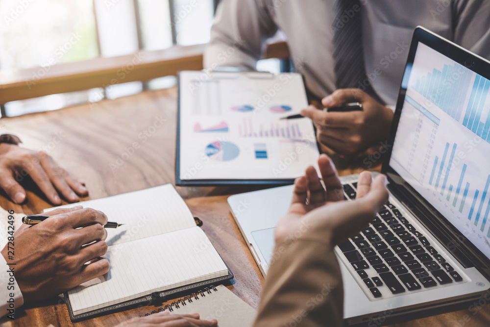 ノートパソコンと資料を使いデータ分析を行うビジネスマンの手元
