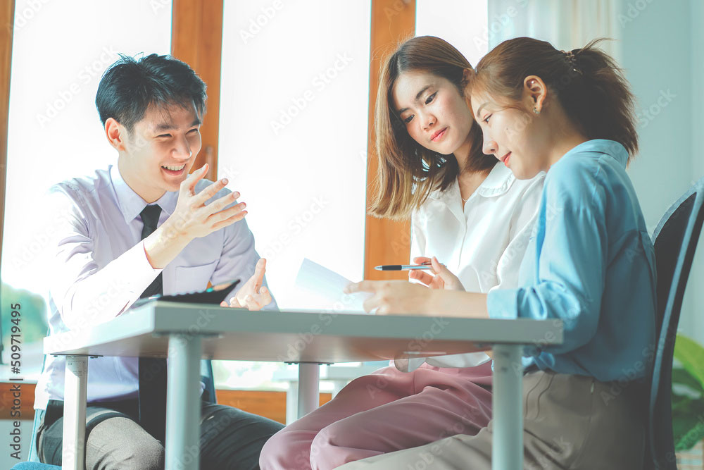 オフィスでスタッフに笑顔で相談をする様子